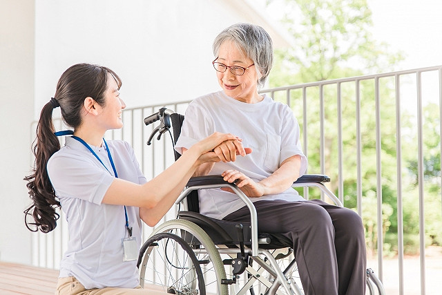 高齢者を介護する看護師女性